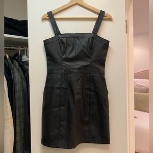 Black faux leather mini dress, adjustable straps with pockets. Never worn size S